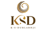 A centered gold and dark brown logo on a plain white background, featuring a spiral emblem above the letters K, S, and D, with the text K.S.